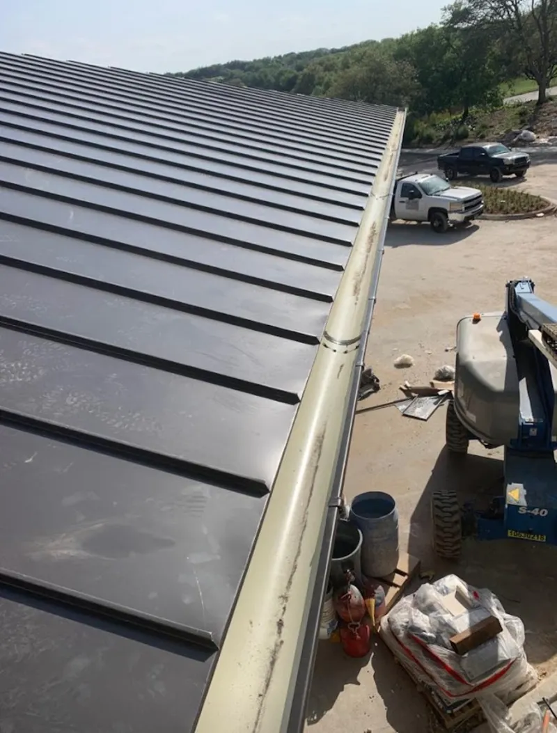 Standing seam panel and gutter detail on a metal roofing jobsite in Sturgis